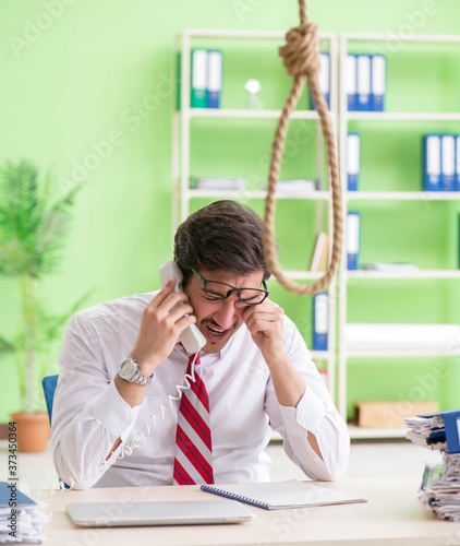Despaired businessman thinking of suicide in the office