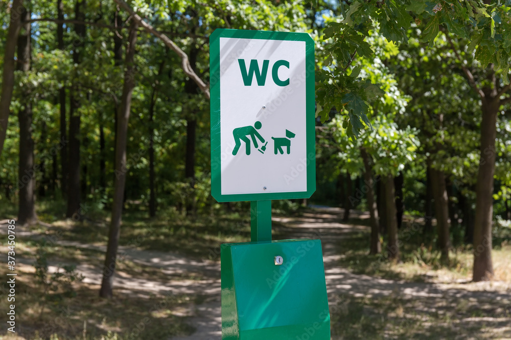 Sign on garbage can for picking of feces after dogs Sign on garbage can for picking of feces after dogs