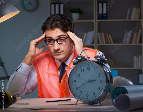 Tired architect working late long hours under stress to meet dea photo