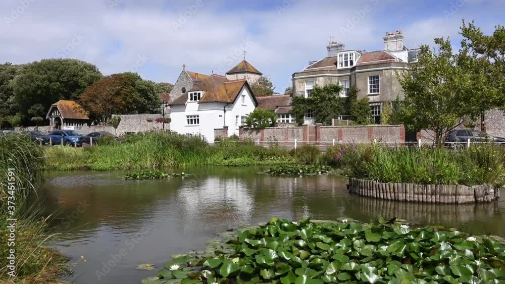 Rottingdean village pond in a scenic setting with traditional English Cottages in the background. Rottingdean village pond in a scenic setting with traditional English Cottages in the background.