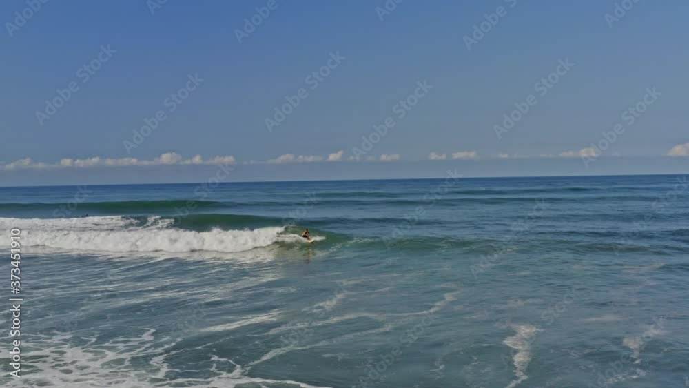 Aerial: awesome surfer riding barrel wave in tropical water Aerial: awesome surfer riding barrel wave in tropical water