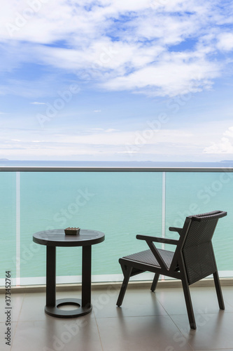 Table and chair with outdoor balcony and sea .The chair and table on balcony sea view. Chair with table set on balcony hotel room with ocean view background.