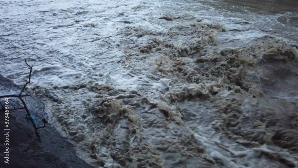 Muddy water flooding after the storm. Flood with rapid waterstream Muddy water flooding after the storm. Flood with rapid waterstream