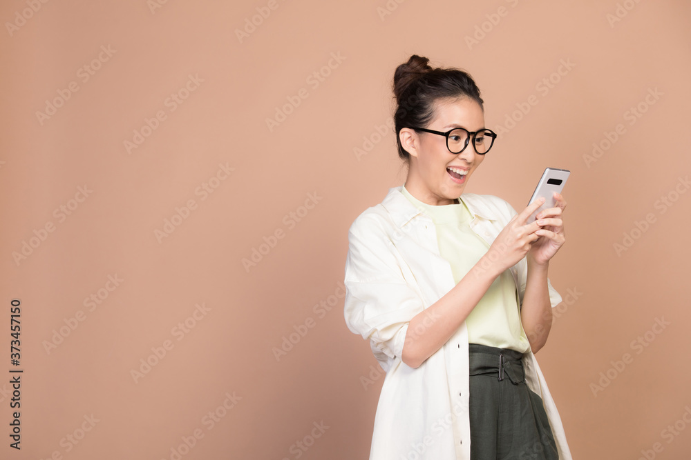 portrait of a young woman holding a mobile phone and laughing portrait of a young woman holding a mobile phone and laughing
