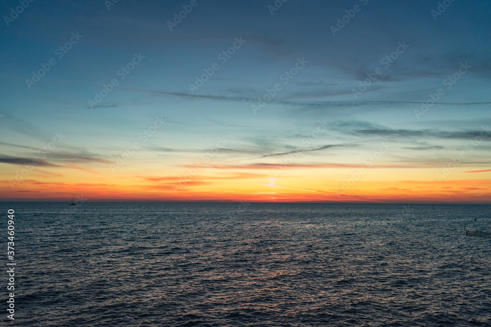 Seascape with a vibrant sunset over a calm sea.
