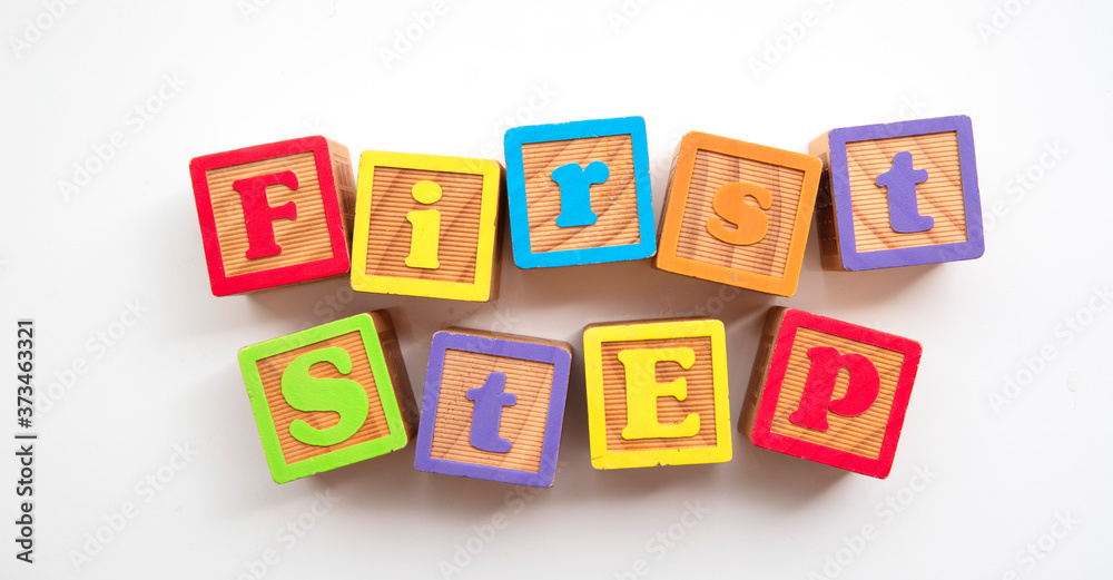 First step word made from colourful wooden baby development blocks