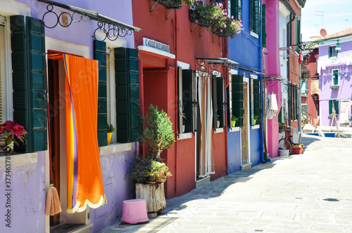 Lonely street in Burano island in Italy. Row of beautifully colored houses © Eva
