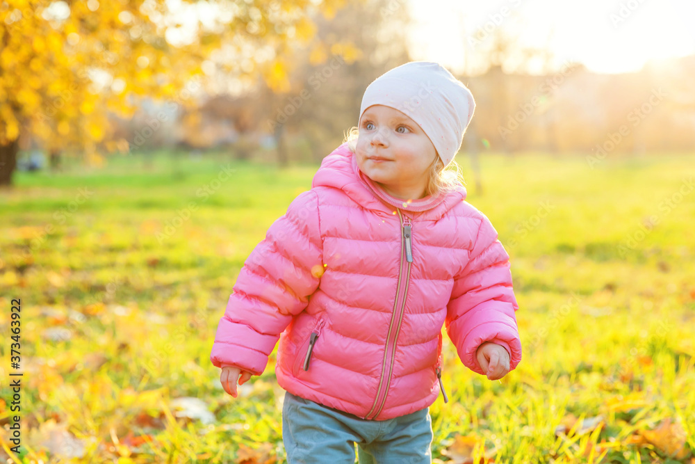 Happy young girl smiling in beautiful autumn park on nature walks outdoors. Little child playing in autumn fall orange yellow background. Hello autumn concept. Happy young girl smiling in beautiful autumn park on nature walks outdoors. Little child playing in autumn fall orange yellow background. Hello autumn concept.