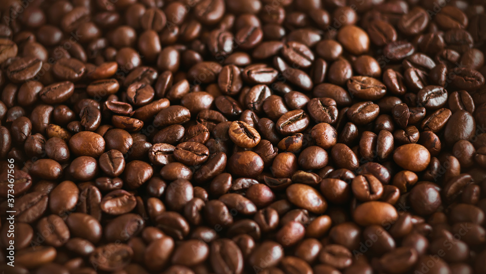 The background shows a lot of roasted natural aromatic coffee beans, which will make a strong invigorating espresso.