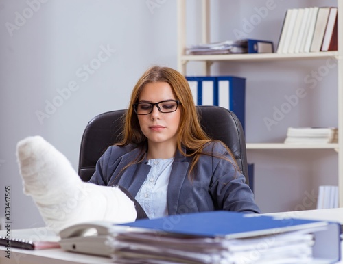 Busiesswoman employee with broken leg in office photo