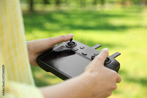 Woman holding new modern drone controller outdoors, closeup of hands