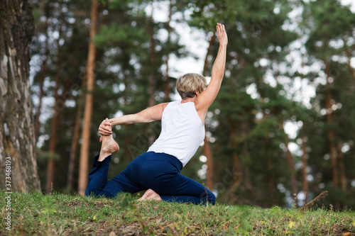 senior woman doing stretching exercise outdoors on a summer morning. yoga. Social Distancing. copy space. Mental Health.
