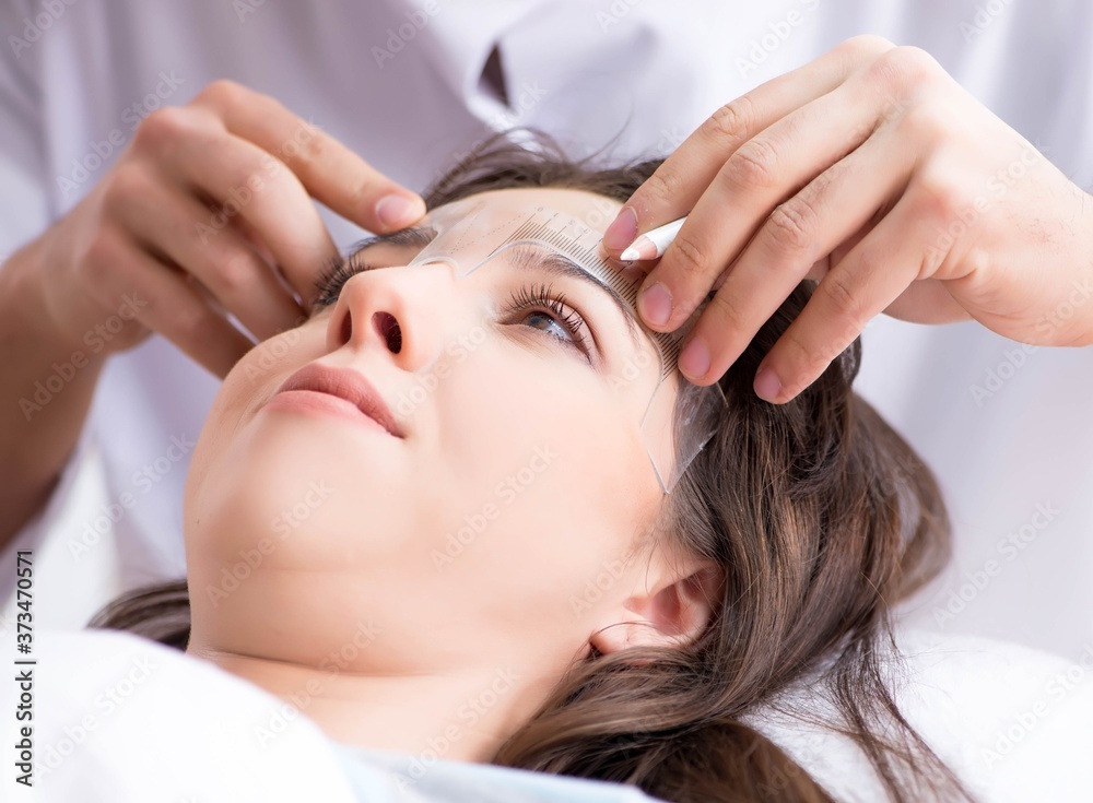 Naklejka premium Doctor measuring patient's face before plastic surgery