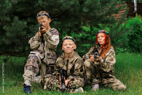 Children playing in lasertag shooting game in open air. Weapon in the hands of people. War simulation.