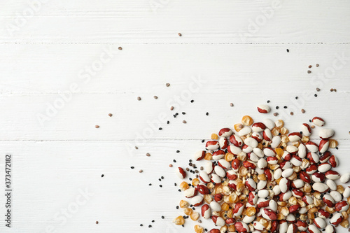 Mixed vegetable seeds on white wooden background, flat lay