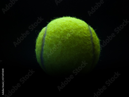 Sports props, close up of tennis ball against a dark background © slobodan