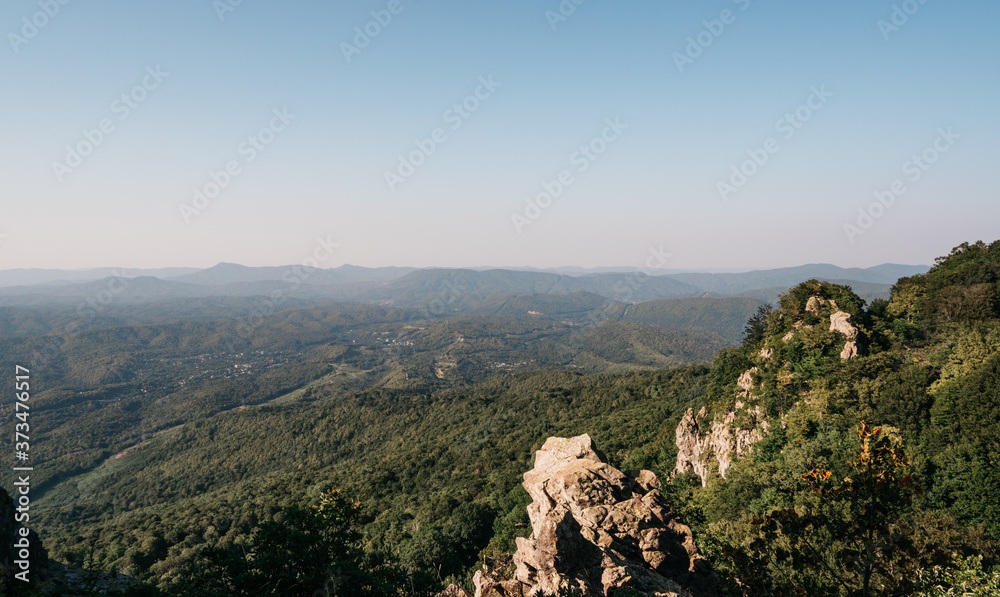 Obraz premium Nature of Russia. Beautiful view of the rocky mountain in the distance. National Park and the Caucasian mountains. Rocks, mountains and dense forest around.
