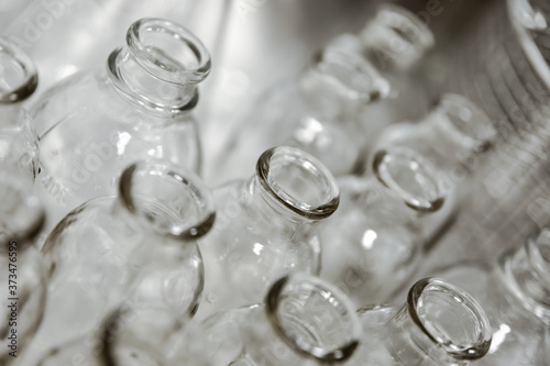 Empty clear glass medicine bottles. Medical manufacturing background