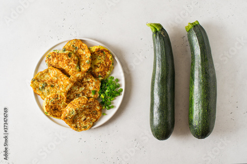 Zucchini pancake with onion and parsley on white background