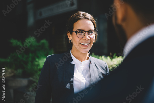 Принти на полотні Smiling woman speaking with colleague in street