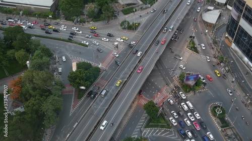 Traffic on crossroad on street. From above modern cars and motorcycles driving on intersection on street in center of Bangkok, Thailand