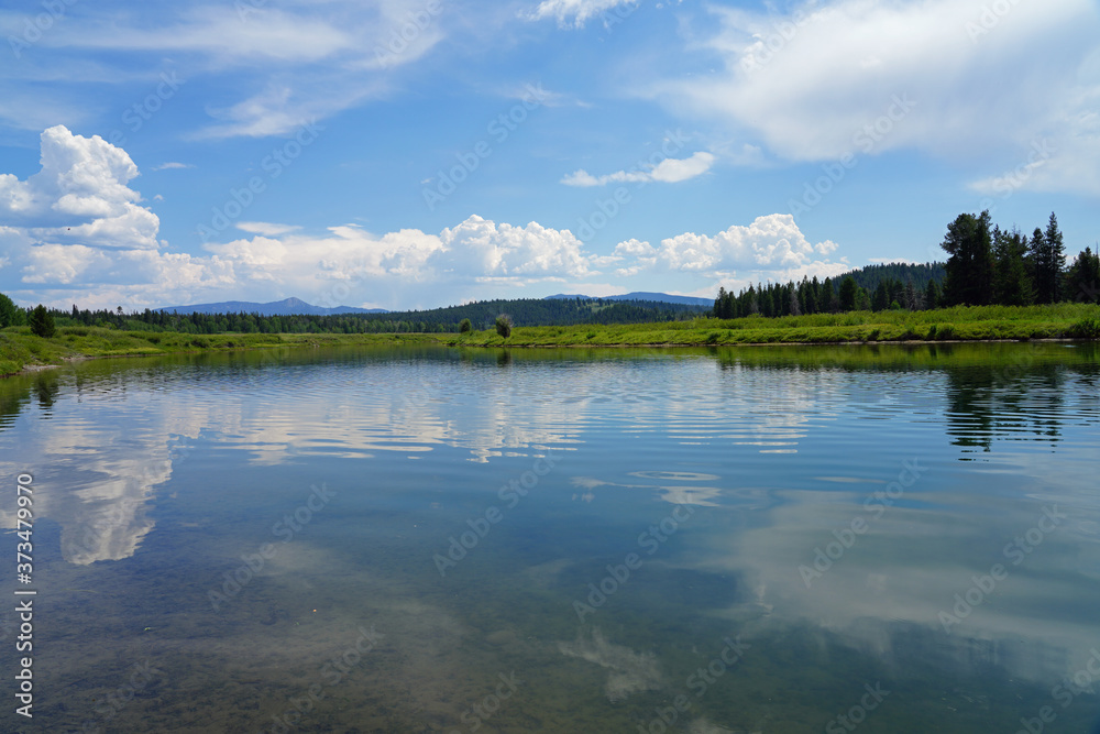 View of mountain peaks reflecting in water in summer in Grand Teton National Park in Wyoming, United States