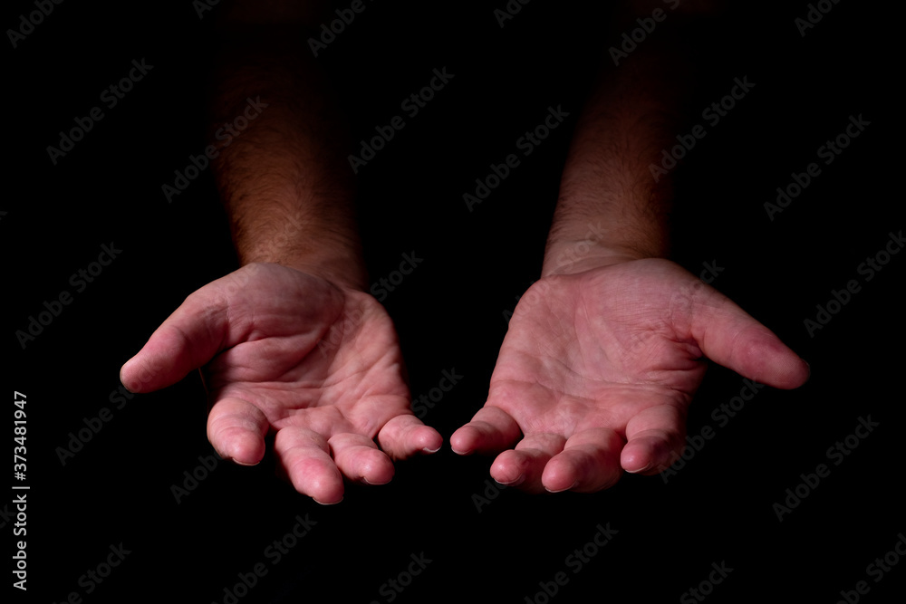 Male hands emerging from the darkness. Hands on a black background. Male hands emerging from the darkness. Hands on a black background.
