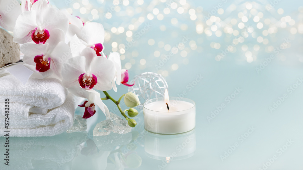 Spa or christmas decoration with white orchid and burning candle Spa or christmas decoration with white orchid and burning candle