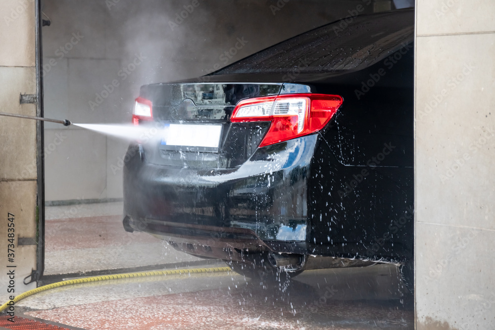 Obraz premium Car washing. Cleaning car with high pressure water and foam