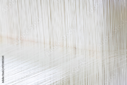 Closed up of loom with white thread background