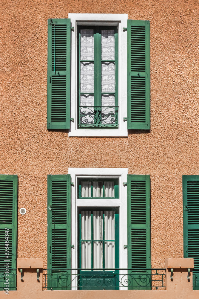 Faded wooden shutters on the windows. Sun protection in hot countries and regions. Architecture in the European province. The facade of a residential building. Retro blinds. Curtains and shutters. Faded wooden shutters on the windows. Sun protection in hot countries and regions. Architecture in the European province. The facade of a residential building. Retro blinds. Curtains and shutters.