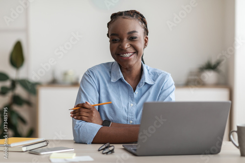Office Worker. Smiling Black Secretary Woman Posing At Workplace, Sitting At Desk