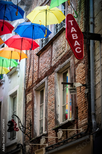 Colorful decoration in the streets with umbrellas and brick wall. Traslation 