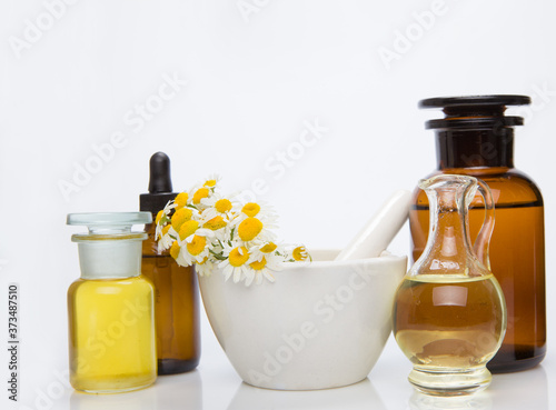 Mortar of healing herbs, bottles of healthy essential oil.