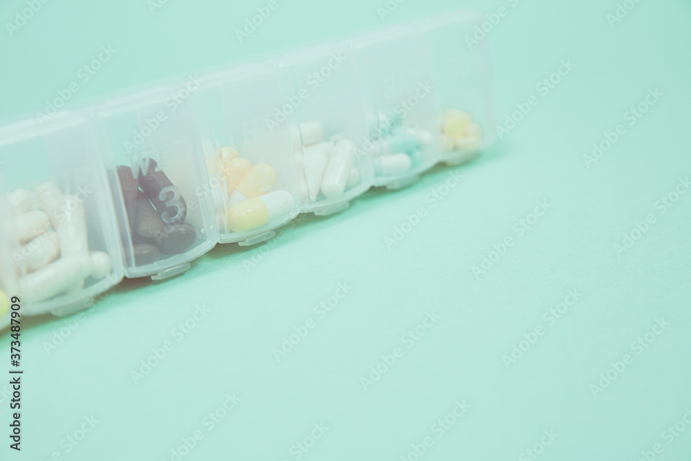 Obraz premium Assorted medical drugs and syringe on blue background