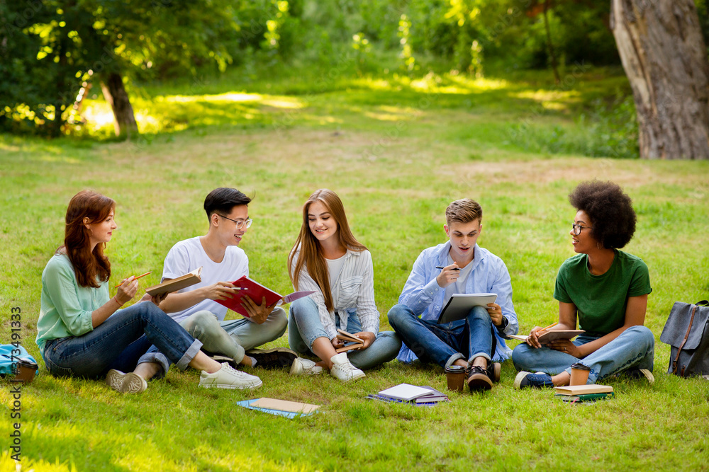 Education Concept. Group of multiethnic students preparing for lectures together outdoors Education Concept. Group of multiethnic students preparing for lectures together outdoors