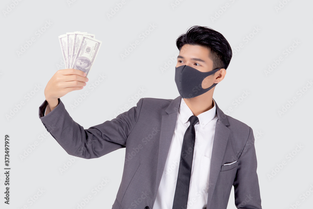 Young asian businessman in face mask holding money dollar isolated on white background, pandemic and crisis of economic, business man in medical mask and investment during disease covid-19. Young asian businessman in face mask holding money dollar isolated on white background, pandemic and crisis of economic, business man in medical mask and investment during disease covid-19.