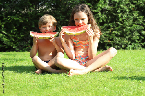 Kinder essen eine Wassermelone im Garten © Anke Thomass