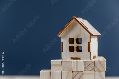 Real estate concept. Small toy wooden house with keys