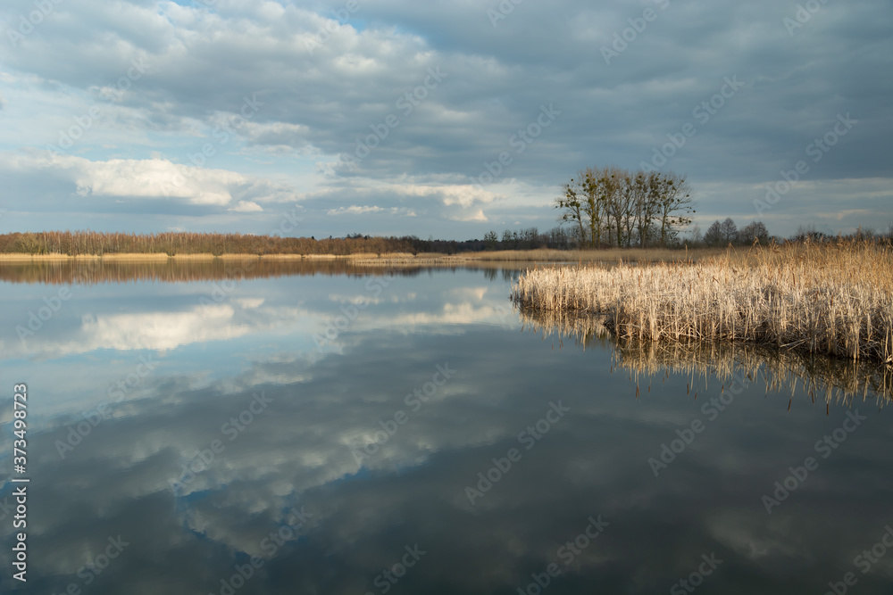 The reflection of dark clouds in a peaceful lake The reflection of dark clouds in a peaceful lake