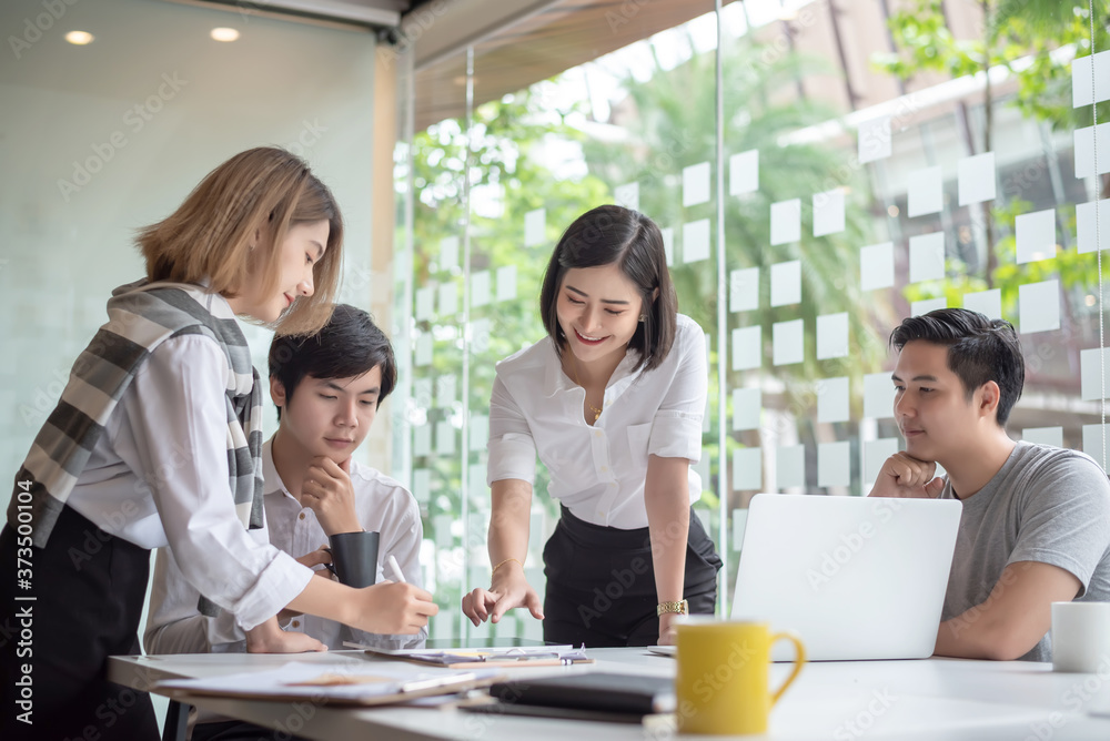 Group of young asian modern people in smart casual wear having a brainstorm meeting. Group of young asian business people discussing in the meeting.