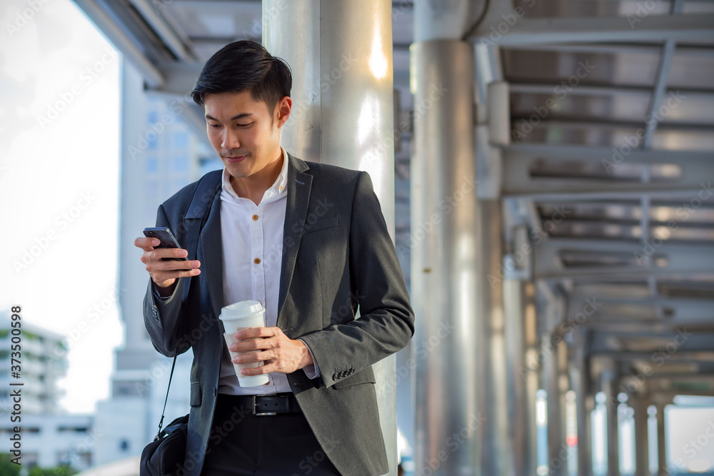 Young businessman who hold a cup of coffe using smart phone. Young businessman who hold a cup of coffe using smart phone.