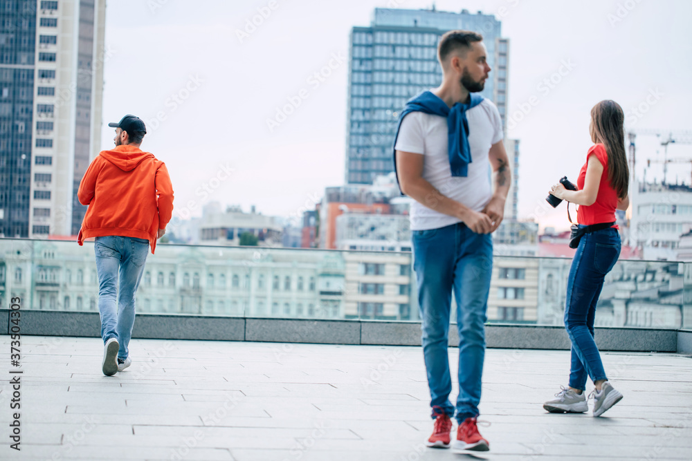 Modern young people in stylish casual clothes are walking outdoors