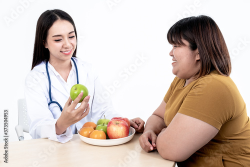 Asian attractive woman doctors  Nutritionists are recommending women patients  Which is obese  eat fruit for weight loss  skin care and health care  On white background.