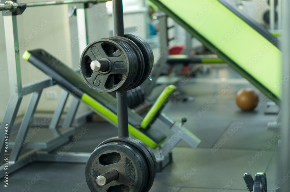 Rack with pancakes for the bar in the fitness room. Equipment in the fitness room for bodybuilding. Rack with pancakes for the bar in the fitness room. Equipment in the fitness room for bodybuilding.