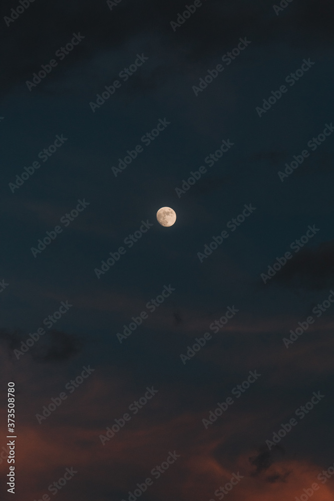 Moon in the sky during the evening besides clouds Moon in the sky during the evening besides clouds