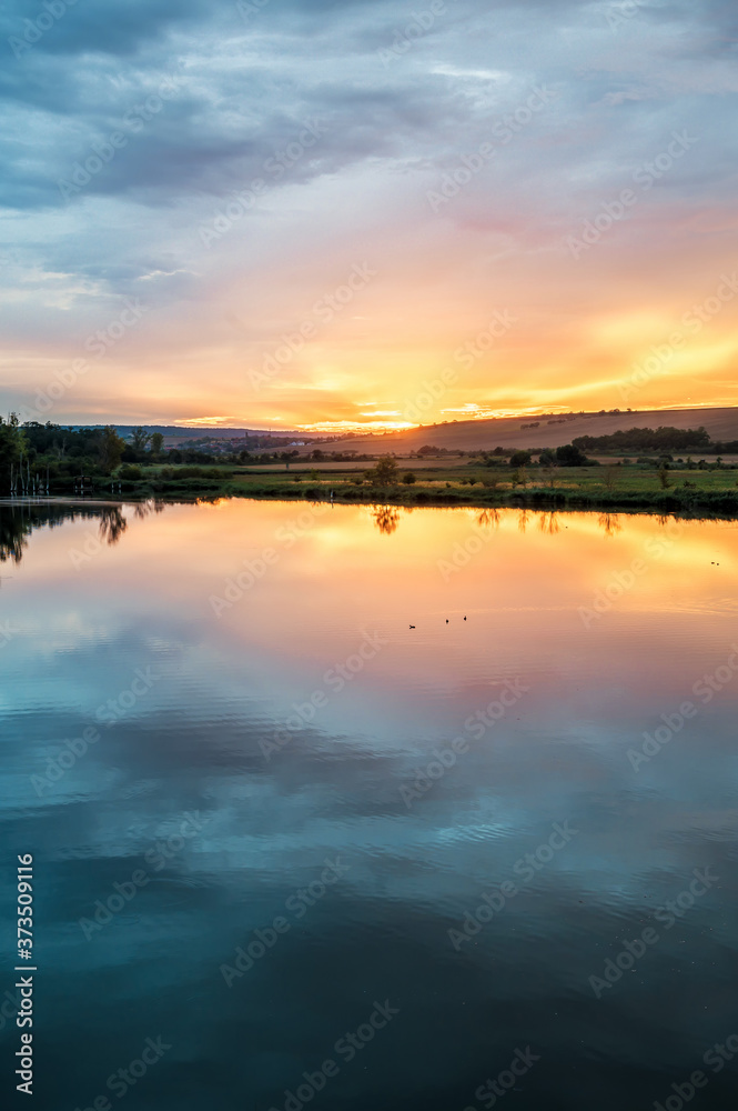 Obraz premium Romantischer Sonnenuntergang über einem See mit Freiraum für individuelle Bearbeitung