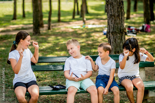 School boy with diabetes testing his blood sugar after physical education, friends support him.
