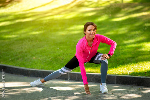 Motivated black woman exercising at public park