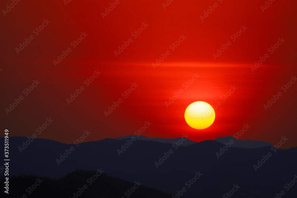 sun dawn on morning sky over silhouette dark mountain and clear red sky